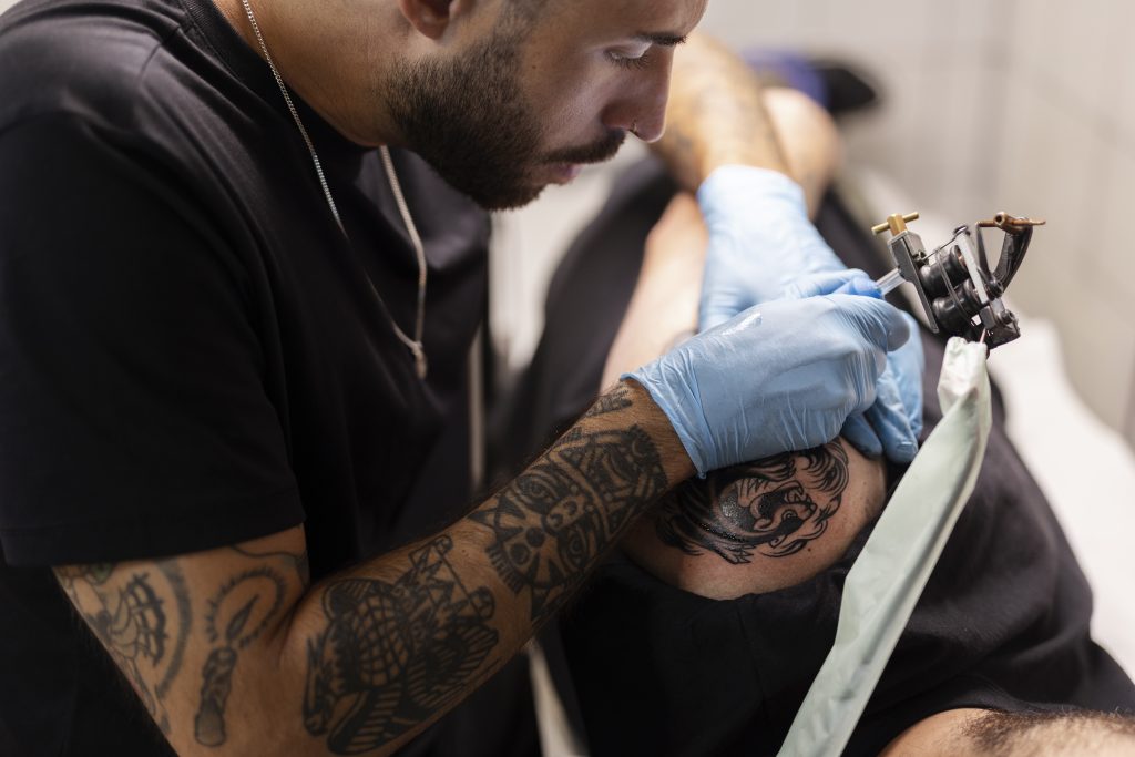 man-tattooing-with-gloves-high-angle